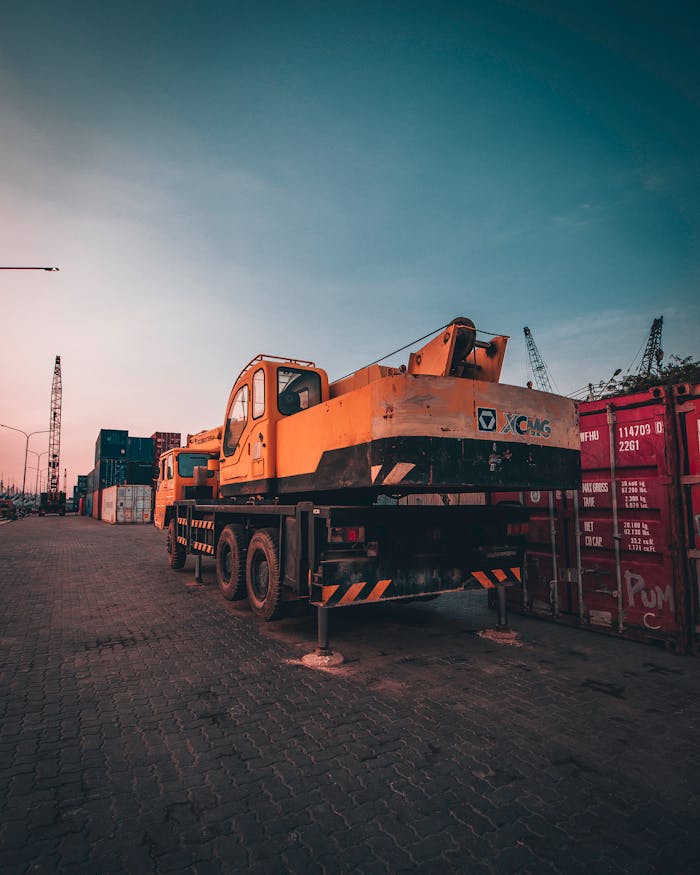 الرئيسية A bustling port with heavy machinery and containers during sunset in Tanjung Priok, Jakarta.